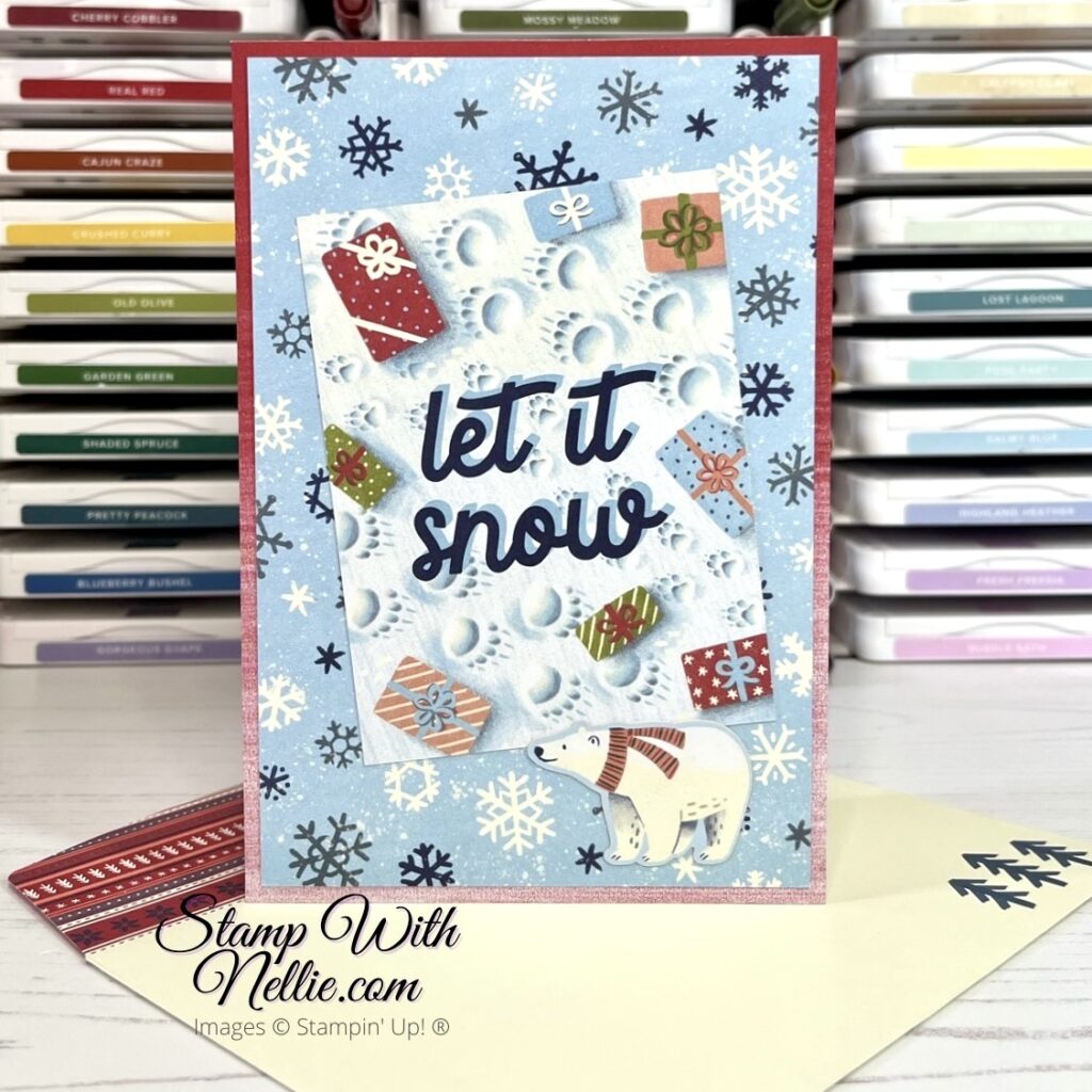 Christmas card with snowflakes in the background and then gifts and pawprints in the snow on top. The greeting is Let It Snow and there's a small polar bear at the bottom