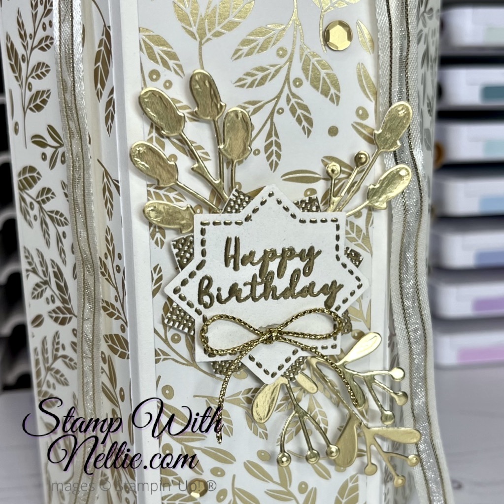 Close up of the cream and gold paper, the happy birthday label and the gold foil die cuts decorating the front of the hexagonal gift box