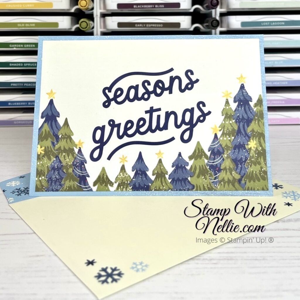 Christmas card with Seasons Greetings and green and blue trees 