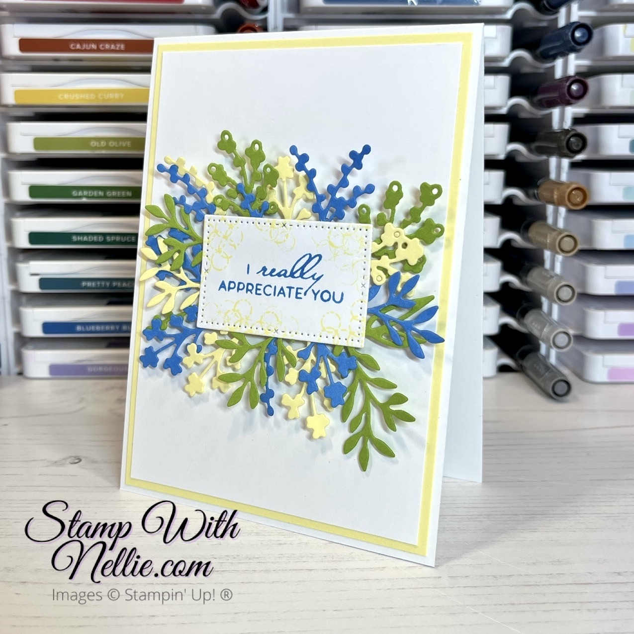 White card with lots of blue, green and light yellow die cut foliage behind a sentiment label.  The sentiment reads I really appreciate you